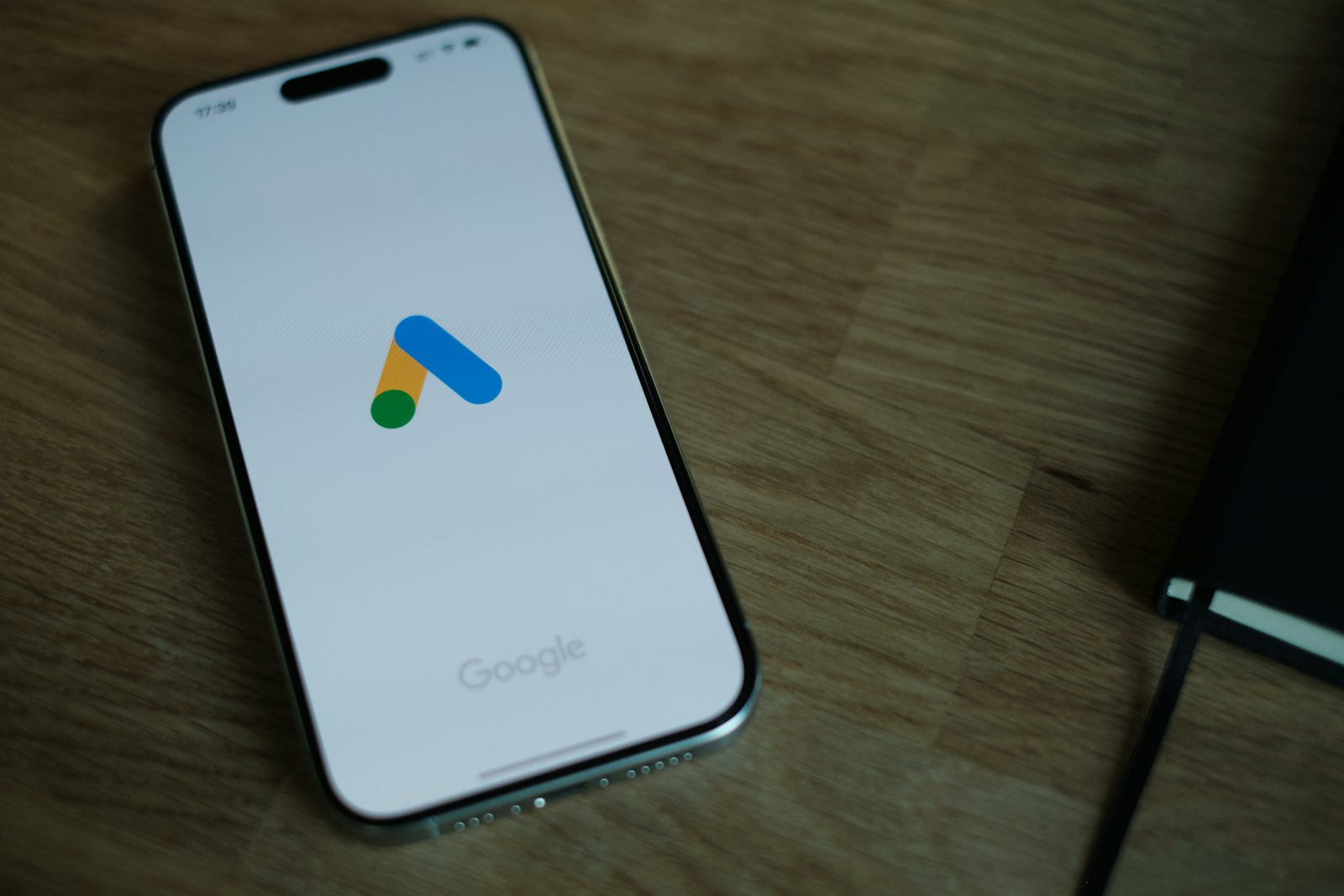 Smartphone displaying the Google Ads logo for a comparison of SEO vs. Google Ads.